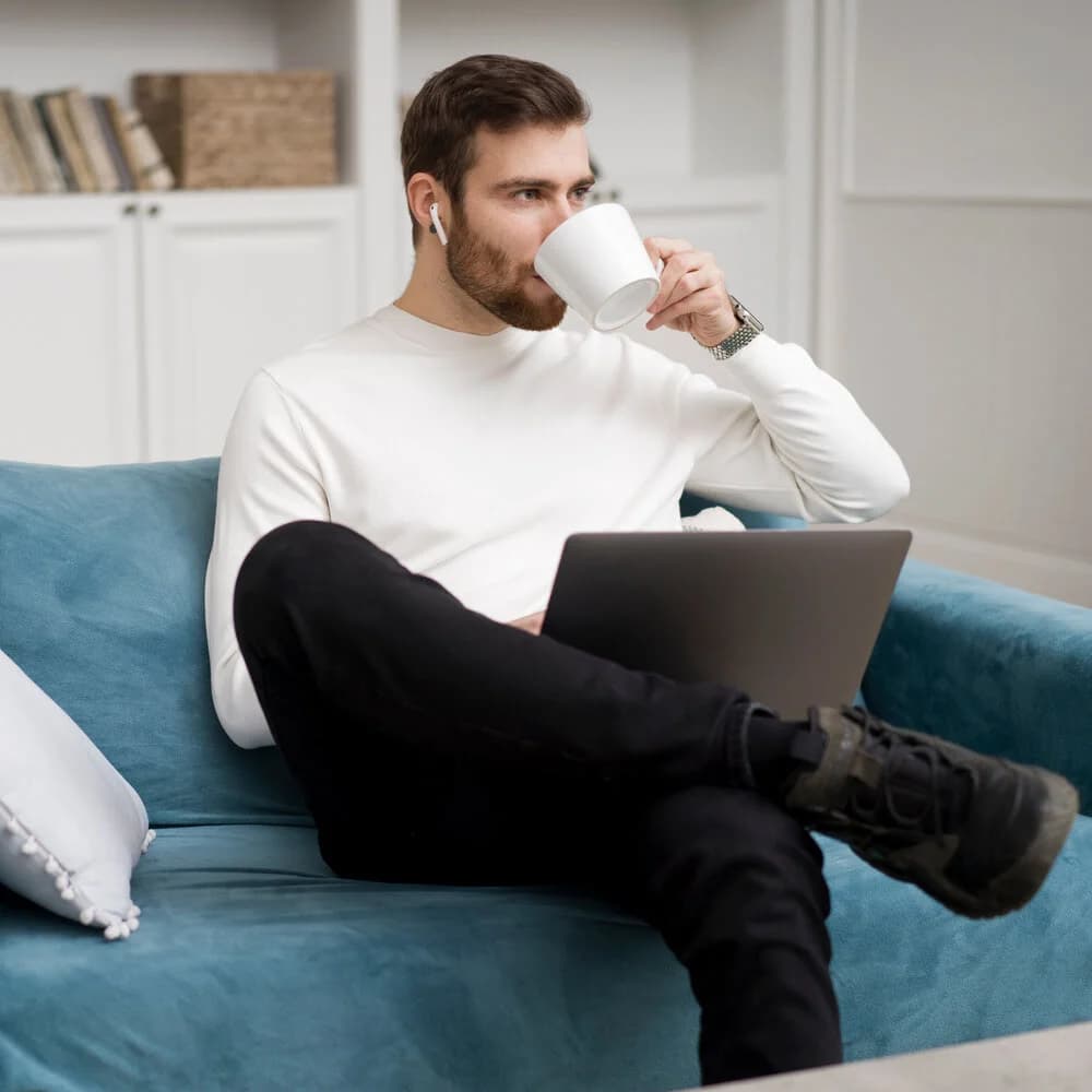 Chat-Moderator arbeitet entspannt von zu Hause mit Laptop und Kaffee